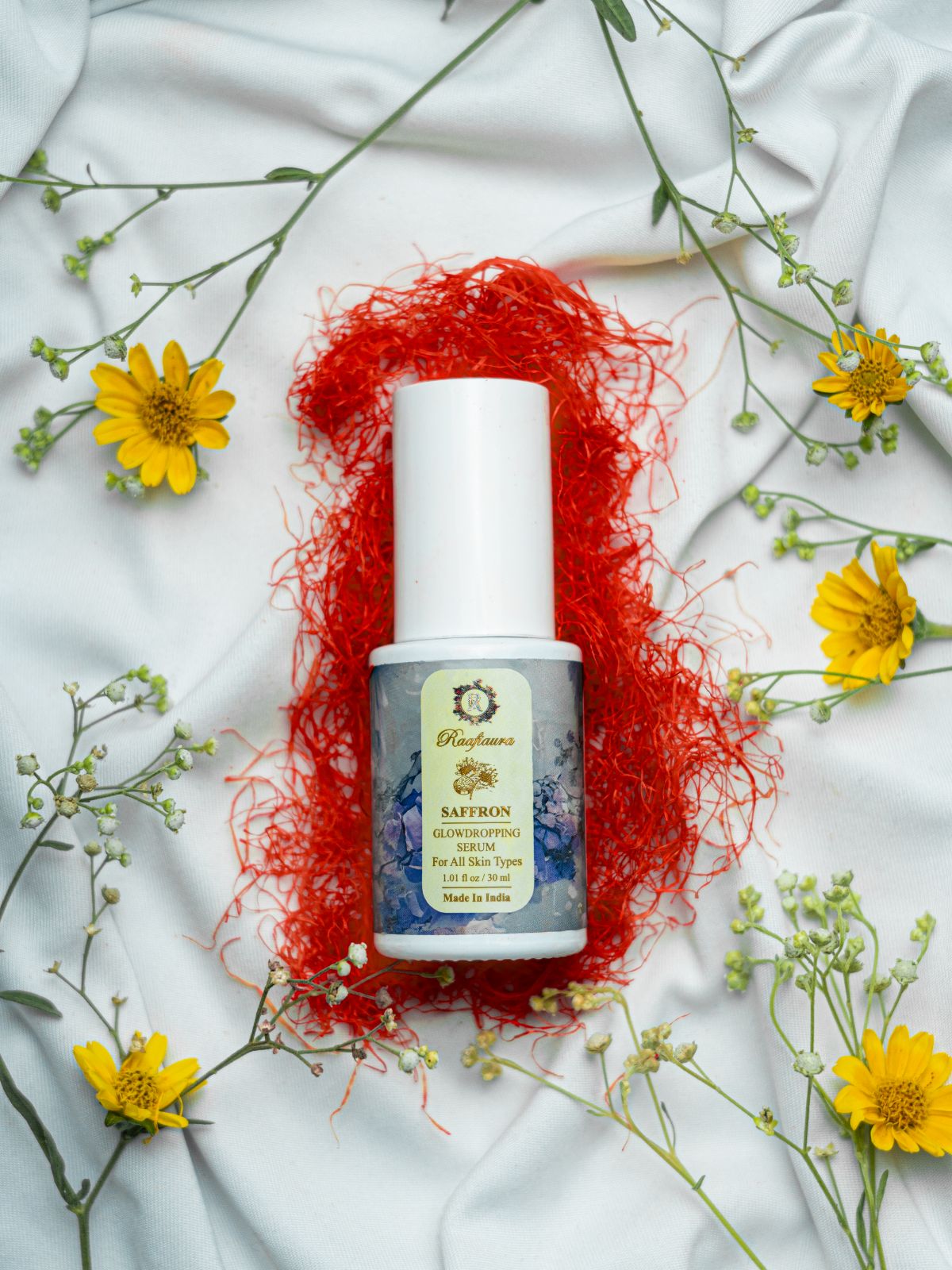 Raafiaura Saffron Glow Dropping Serum on a floral background for glowing skin