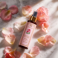 Raafiaura Pink Peta Face Mist in a spray bottle surrounded by pink rose petals