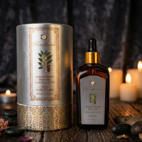 Raafiaura Radiant Bliss Body Oil with Almond and Oud in an elegant glass bottle next to lit candles