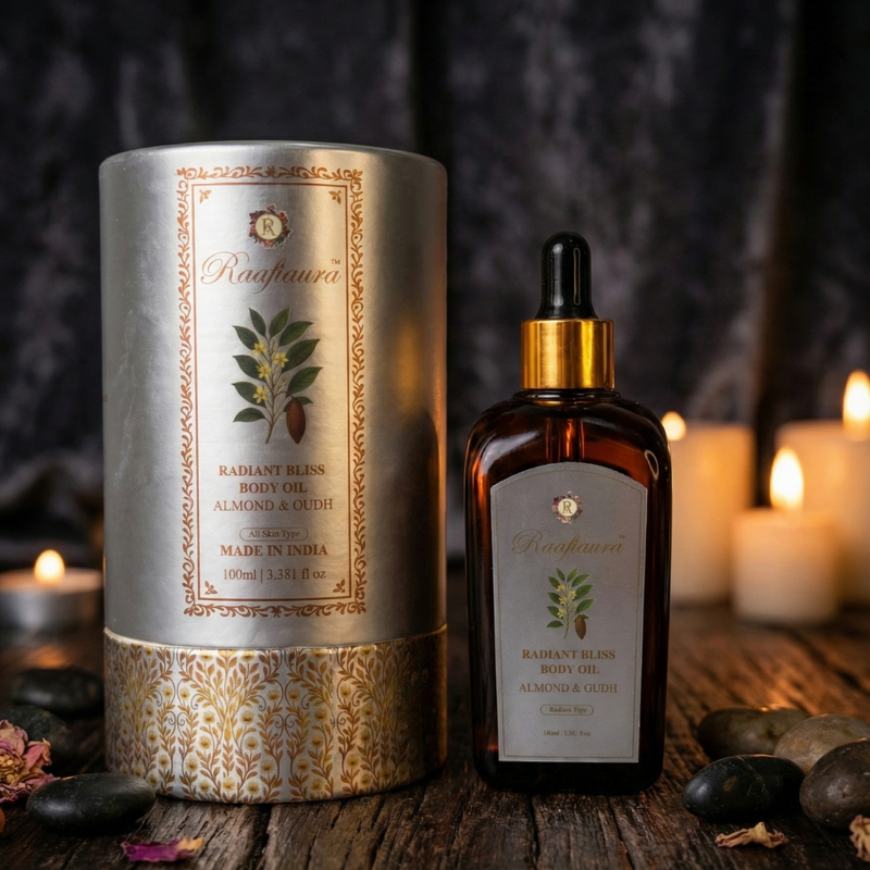 Raafiaura Radiant Bliss Body Oil with Almond and Oud in an elegant glass bottle next to lit candles